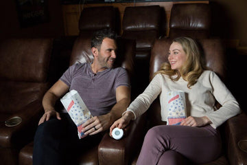 A man and a woman with Linxura Smart Controller eating popcorn